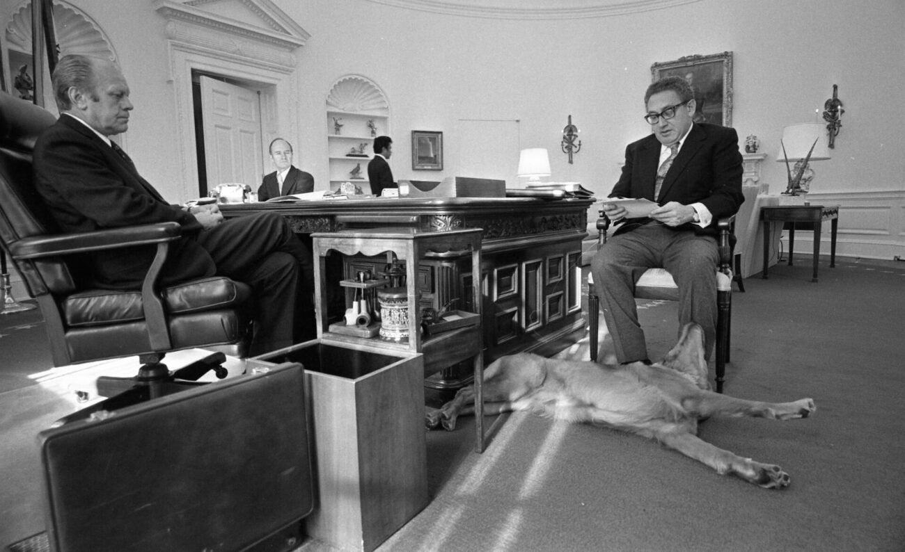 Liberty, de hond van de Amerikaanse president Gerald Ford, aan de voeten van Henry Kissinger in het Witte Huis, 1974.