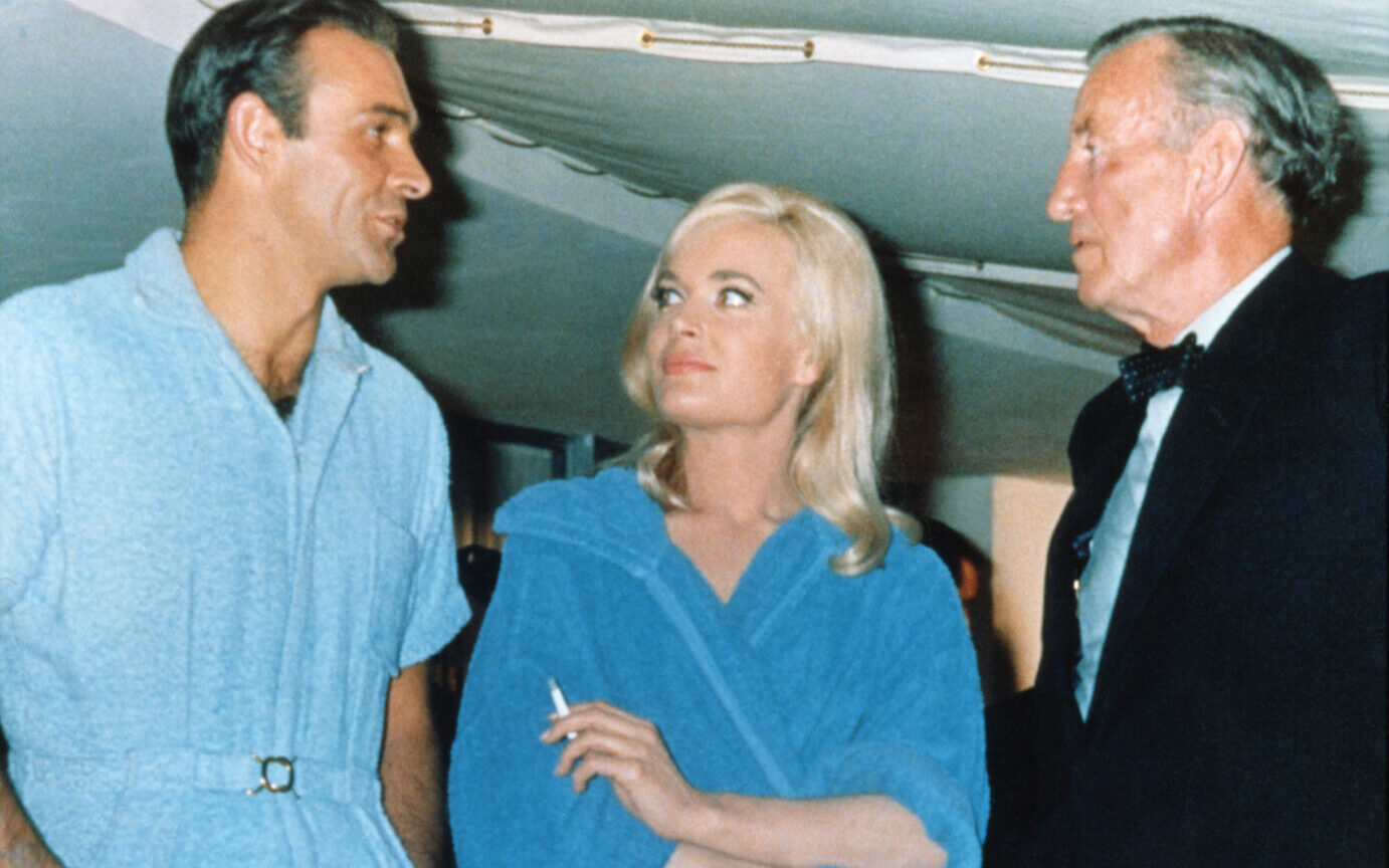 Actor Sean Connery, Ian Fleming and actress Shriley Eaton on the set of "Goldfinger". (Photo by Sunset Boulevard/Corbis via Getty Images)
