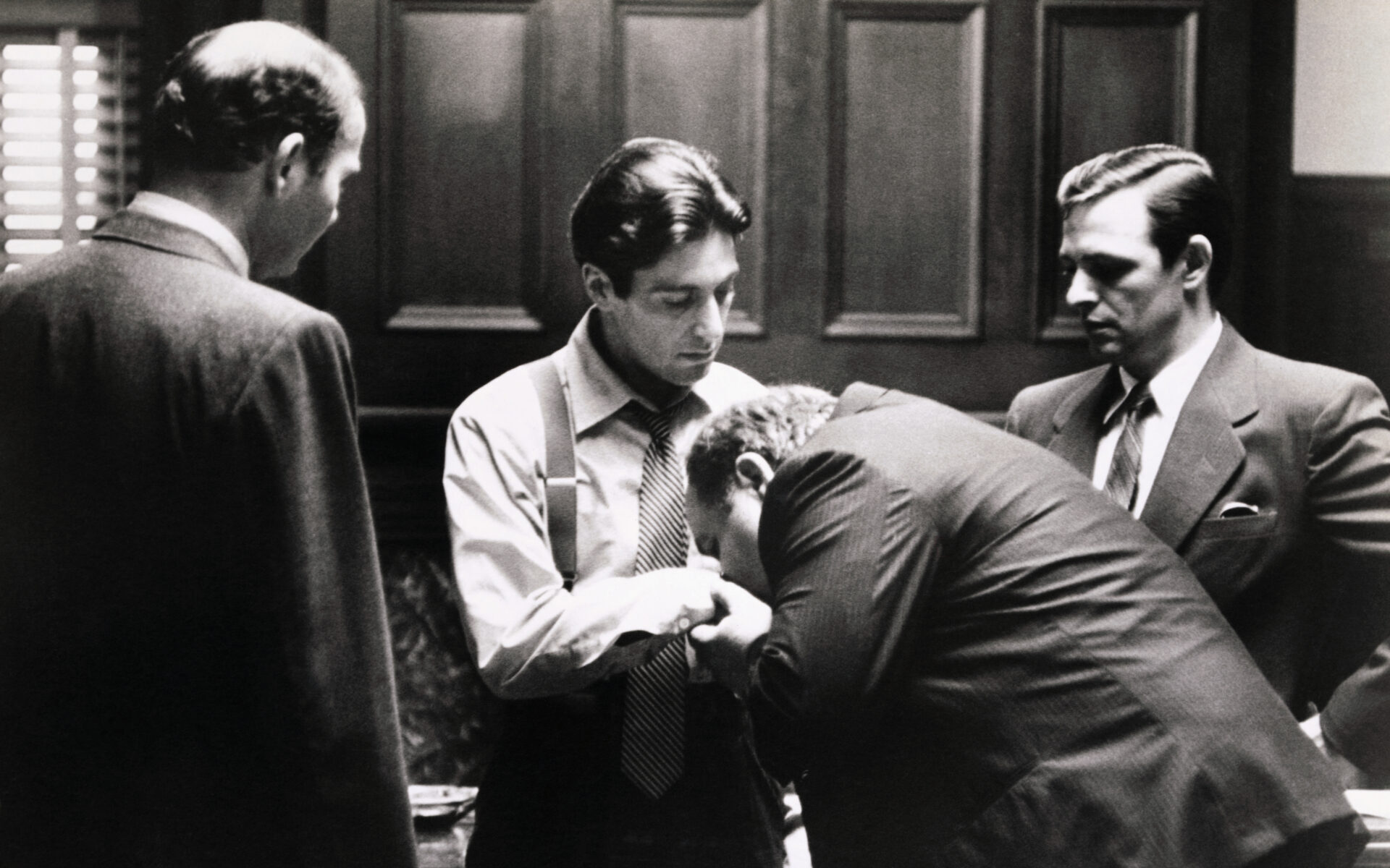 Clemenza (Richard Castellano) kisses the hand of the new "Godfather", Michael Corleone (Al Pacino), in the last scene of The Godfather.